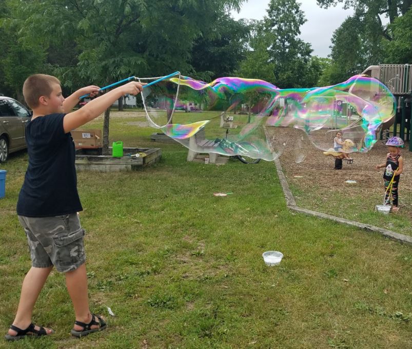 kid making giant bubble